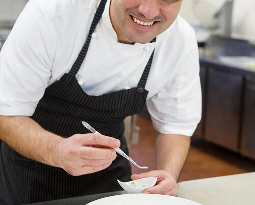 Jonatán Gómez Luna en la cocina de Le Chique preparando un platillo, ganador del Mentor Chef Award 2025 de la Guía MICHELIN México